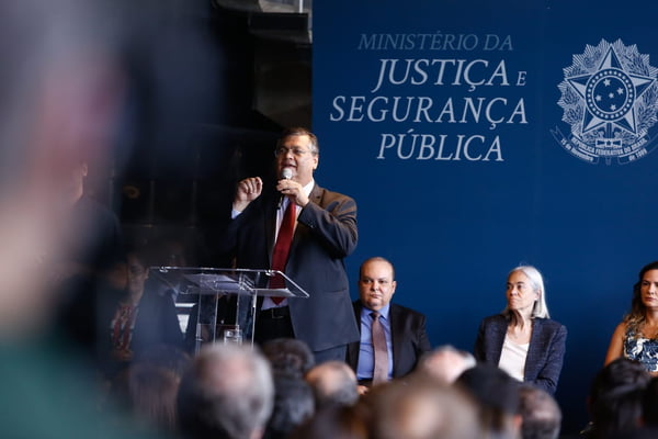 Posse do ministro Flávio Dino, ministro da justiça e segurança, em que discursa no ministério diante de púlpito e com microfone na mão - Metrópoles