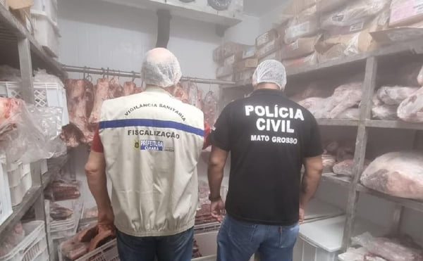 Foto de dois agentes (um da polícia civil e outro da vigilãncia sanitária de MT) em um açougue no Cuiabá -Metrópoles