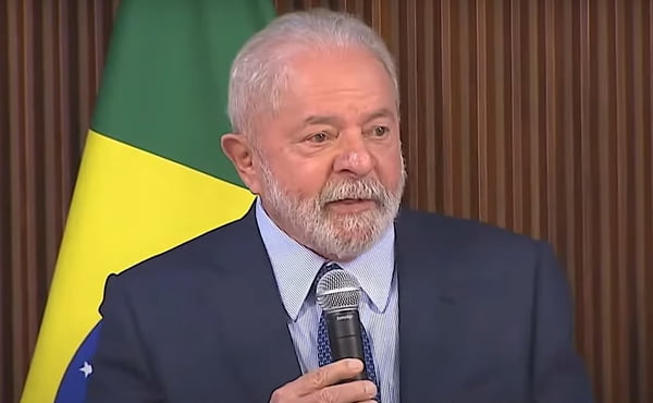 Presidente Lula fala a governadores em encontro no Palácio do Planalto. Ele segura microfone, diante de bandeira do Brasil - Metrópoles