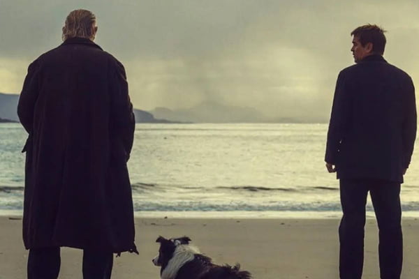 Foto colorida de dois homem e um cachorro olhando para o mar - Metrópoles
