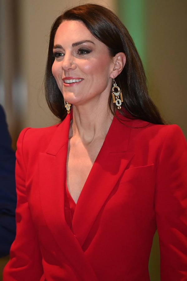 Foto colorida de mulher branca, maquiada, de cabelos castanhos e de roupa vermelha - Metrópoles