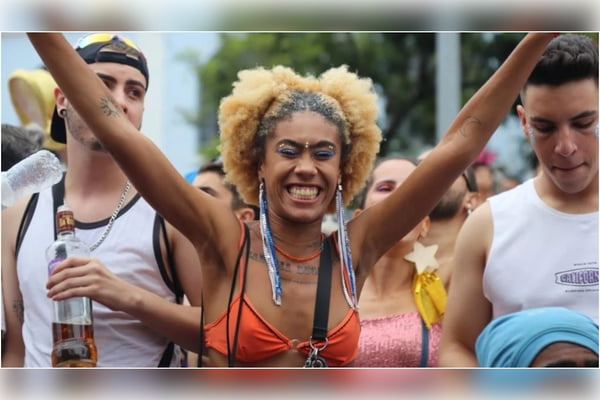 mulher negra com adornos de carnaval de braços abertos e sorrindo