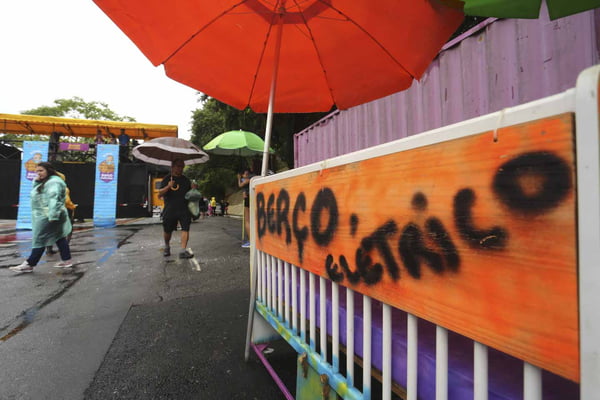 Pessoas com guarda-chuva no bloco de carnaval Berço elétrico - metrópoles