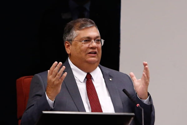 foto colorida do ministro Flávio Dino de terno, mãos levantadas, em reunião no STF sobre Marco Civil da Internet