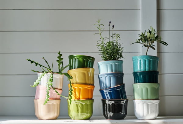 Vasos de planta de dversas cores, azul, laranja, branco, amarelo , verde com algumas plantas dentro - metrópoles