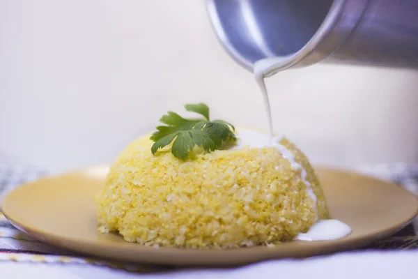 Cuscuz – Traditional dish from northeastern Brazil. Cuscuz can be made from flour, corn, rice or cassava. Milk being poured into couscous