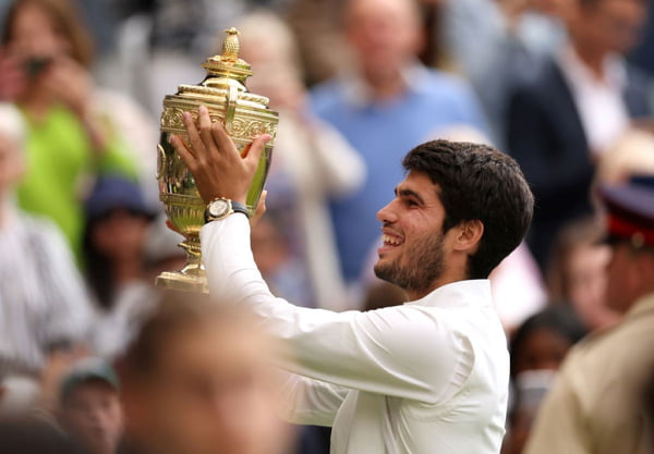 Jogador de tênis Carlos Alcaraz segura troféu de campeão em Wimbledon - Metrópoles