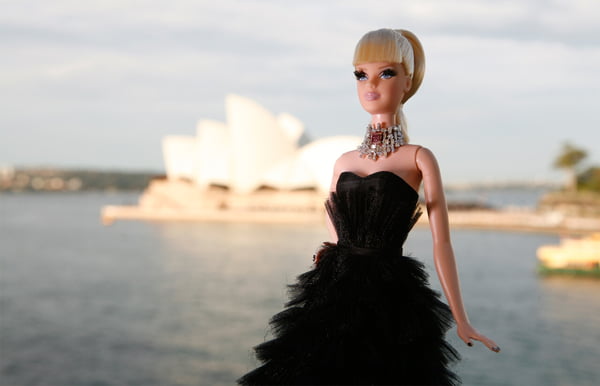 Na foto, uma barbie loira com um vestido preto - Metrópoles