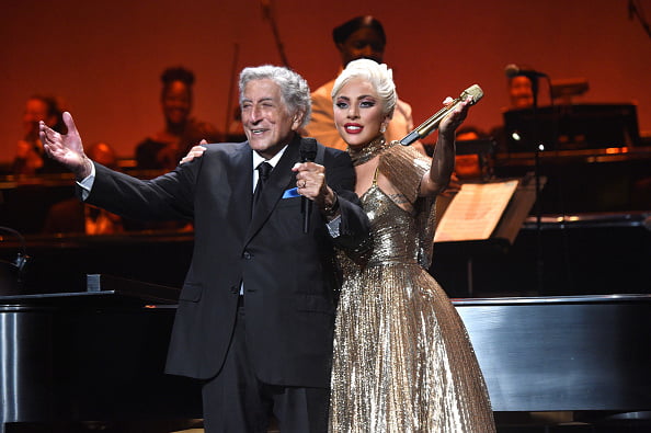 Foto colorida de Tony Bennett no palco com Lady Gaga - Metrópoles