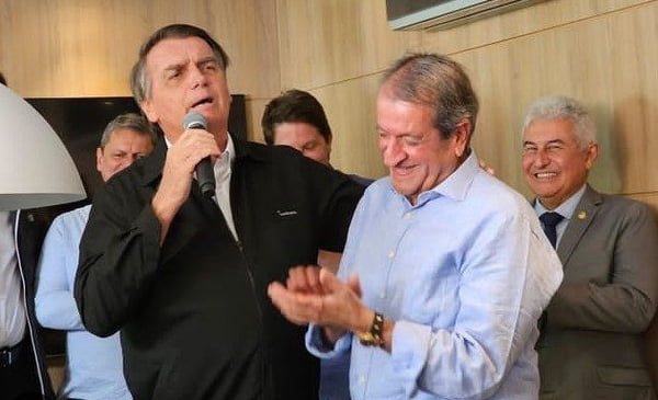 Partido Imagem colorida de Jair Bolsonaro com um microfone na mão ao lado de Valdemar Costa Neto sorrindo e aplaudindo - metrópoles
