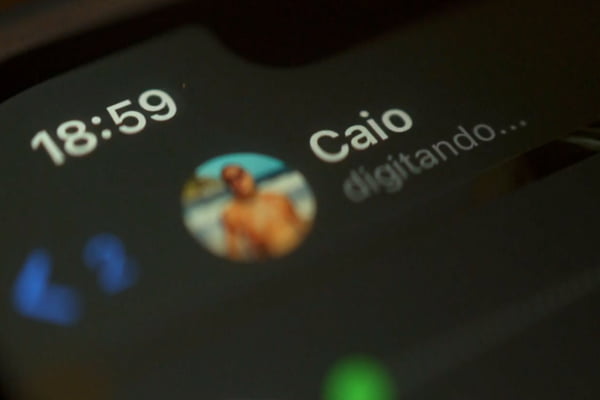 Imagem colorida de homem com nome de Caio digitando no WhatsApp - Metrópoles