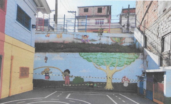 Imagem colorida mostra fita zebrada interditando terreno de escola em São Paulo. Muro ao fundo tem desenhos infantis - Metrópoles