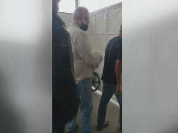 Foto colorida de médico Alexandre Pedroso ao lado de policiais momentos após a morte de paciente
