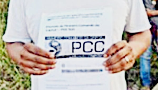 Abin PCC CV imagem colorida mostra pessoa segurando papel com a sigla pcc escrita em letras grandes - Metrópoles