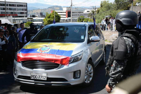 imagem colorida mostra carro prata com bandeira do equador que leva o corpo do candidato à presidência Fernando Villavicencio do Equador - Metrópoles