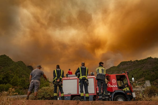 Imagem colorida mostra bombeiros observando incêndio florestal em Tenerife, na Espanha - Metrópoles