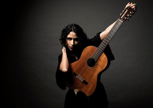 Fotografia colorida de Marisa Monte com um violão