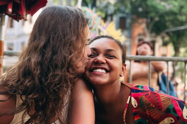 Foto colorida da influencer Jessi Alves sorrindo ao lado da namorada, a produtora Sté Frick - Metrópoles