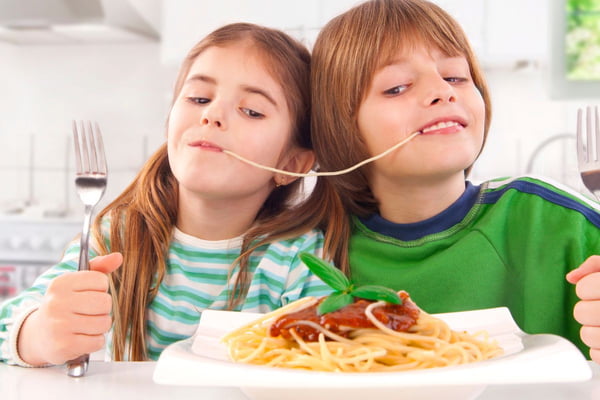 Crianças comendo macarrão