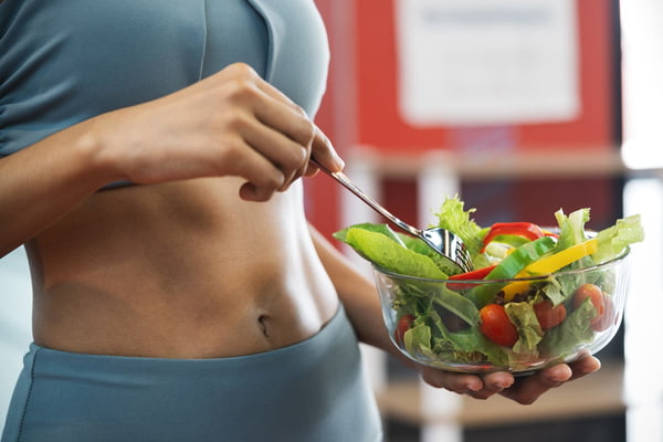 Foto mulher segurando tigela de vidro com verduras e legumes dentro - Metrópoles - comida saudável