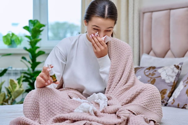 Mulher com alergia, gripe nariz escorrendo de cama - Metrópoles