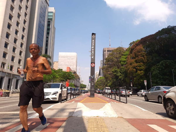 foto colorida mostra idoso correndo sob o sol em trecho da Avenida Paulista - Metrópoles