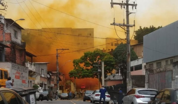 Imagem colorida mostra uma fumaça laranja no meio de uma rua com casas na cidade de Barueri após o vazamento de um produto químico - Metrópoles