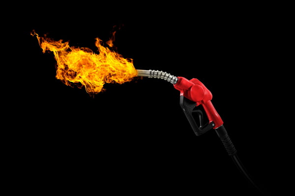 Fotografia de uma bomba de gasolina saindo fogo pelo "bico"