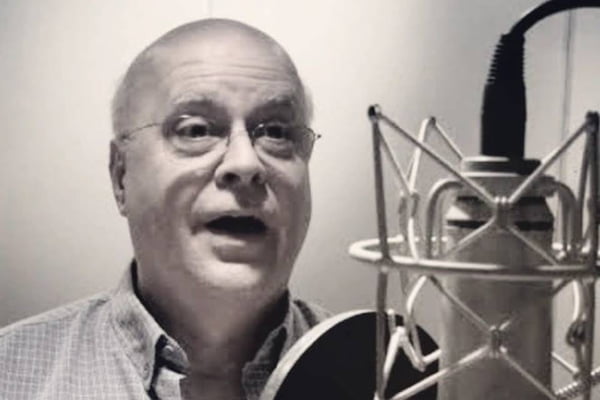 Foto em preto e branco de Reinaldo Pimenta falando em microfone - Metrópoles