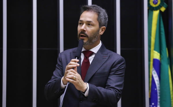 Fotografia colorida mostra Saulo, um homem grisalho e com barba, segurando um microfone no plenário da Câmara dos Deputados - Metrópoles