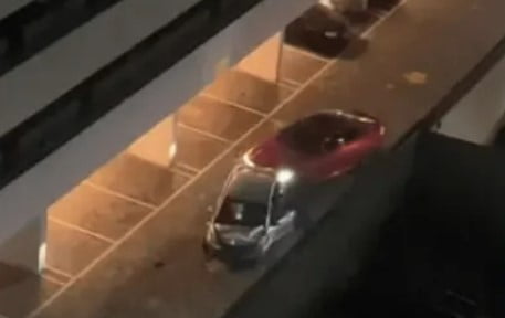 Imagem colorida mostra um carro vermelho, de MC Paiva, arrastando um carro prata dentro de um estacionamento em São José dos Campos, interior de São Paulo - Metrópoles