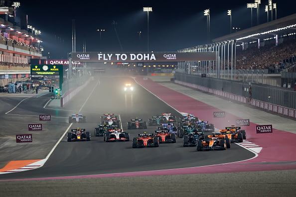 Imagem colorida de carros de Fórmula 1 em curva no cirucuito do GP do Catar - Metrópoles