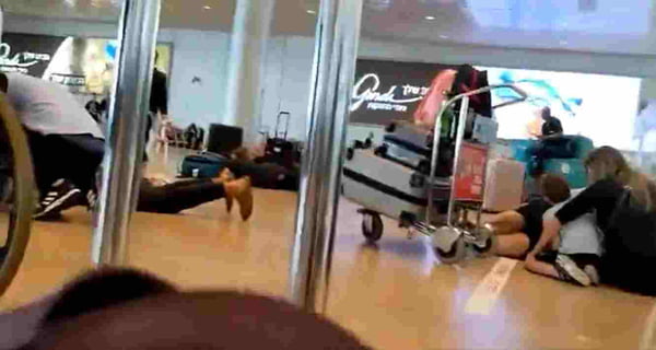 Imagem colorida de pessoas deitas no chão em aeroporto após ataque - Metrópoles