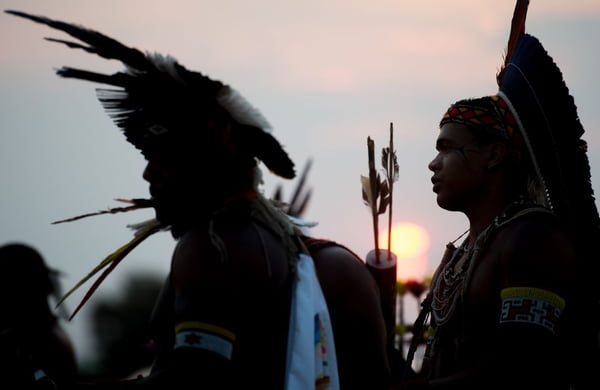 foto colorida de indígenas com por do sol - Metrópoles