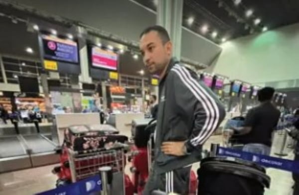 foto colorida do líbio Ahmed Hasan à espera de bagagem no aeroporto - Metrópoles