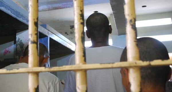 Em foto colorida, homem dentro de cela de prisão - Metrópoles