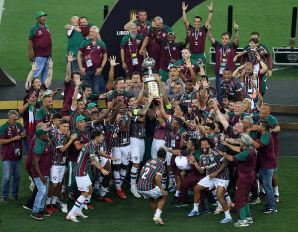 Imagem mostra jogadores do Fluminense comemorando com a taça da Libertadores - Metrópoles