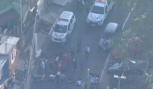 Imagem aérea de avenida bloqueada por protesto de moradores; duas viaturas da PM estão no local - Metrópoles