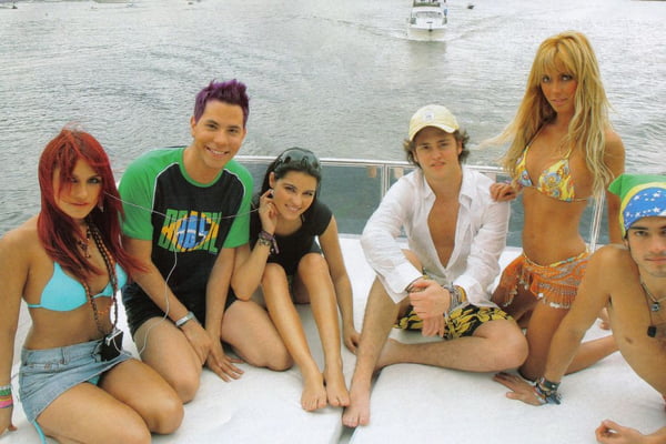 Foto colorida do grupo RBD na praia - Metrópoles