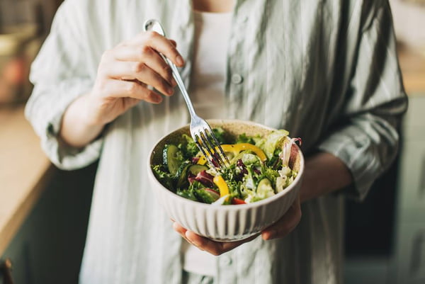 Foto colorida das mãos de uma mulher segurando um bowl com salada - Metrópoles - dieta