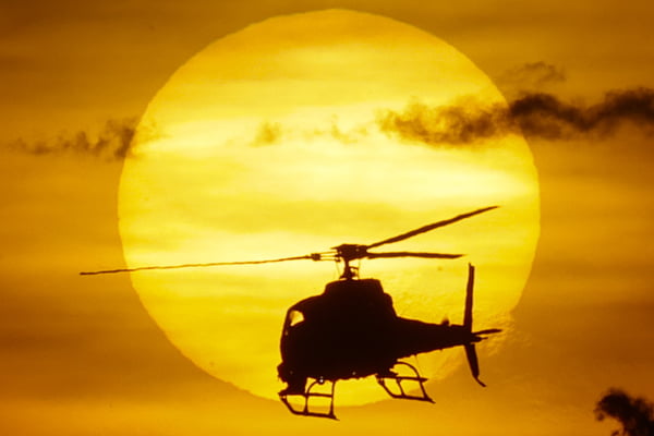 Helicóptero passa pelo sol no fim de tarde - Metrópoles