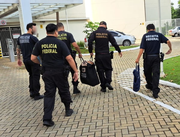 Imagem de agentes da Polícia Federal e Receita Federal caminhando com bolsas - Metrópoles