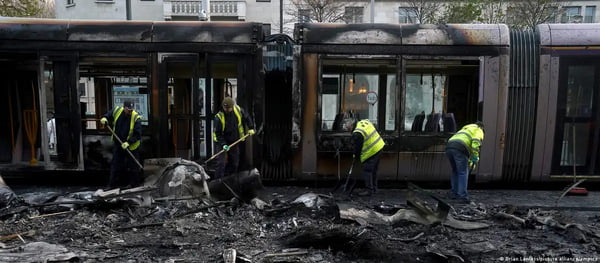 Funcionários limpam infraestrutura de transporte que foi incendiada no centro de Dublin