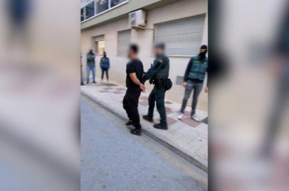 Foto colorida da guarda civil da Espanha conduzindo brasileiro preso - Metrópoles
