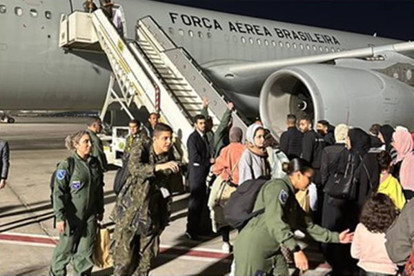 Foto colorida dos 48 brasileiros embarcando no avião da FAB após deixar Gaza - Metrópoles