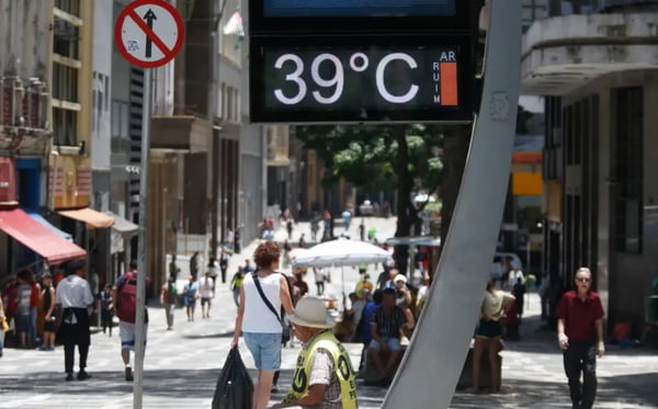 foto colorida de paulistanos caminhando sob o sol no centro de SP, com termômetro marcadno 39 graus - Metrópoles