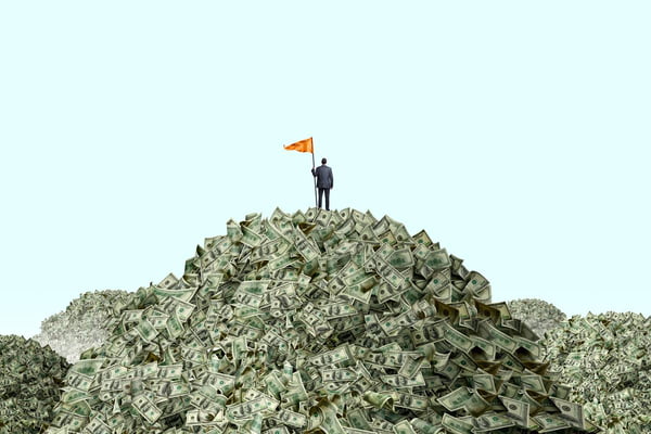 Homem finca bandeira sobre uma montanha de dinheiro - Metrópoles