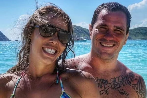 Julia Araujo e Diego Braga posam juntos e sorridentes na praia - Metrópoles