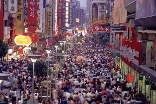 Imagem de multidão de pessoas nas ruas de área de comércio na China - Metrópoles
