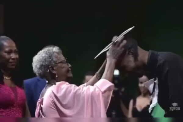 Foto mostra avó colando grau de neto durante cerimônia de formatura ao som de Negro Drama